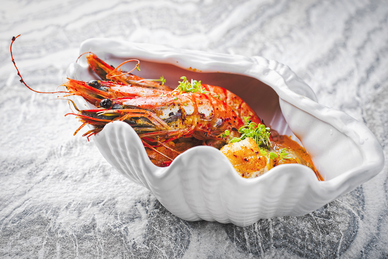 Traditional cajun stew red curry with king prawns, fish and red